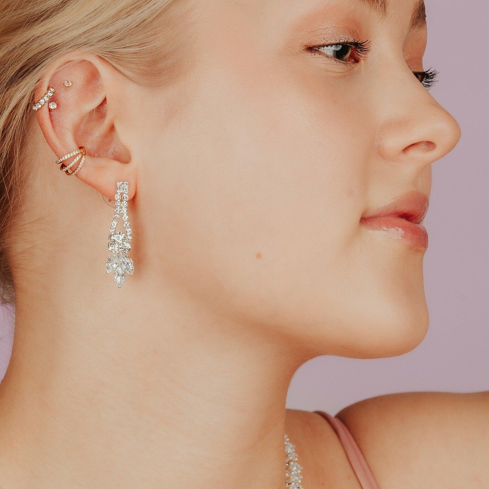 Grace korvakorut mallin korvassa – pitkät, kirkkaasti kimaltavat juhlakorvakorut.