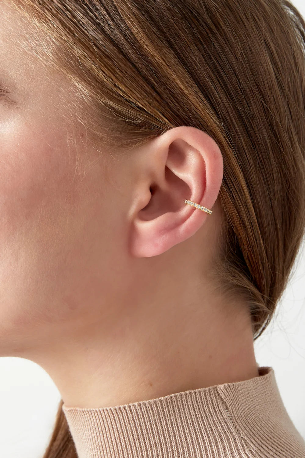 Celeste -ear cuff hopeanvärisenä, sileä metallikaari ja kirkkailla Cubic Zirconia -kivillä koristeltu osa.