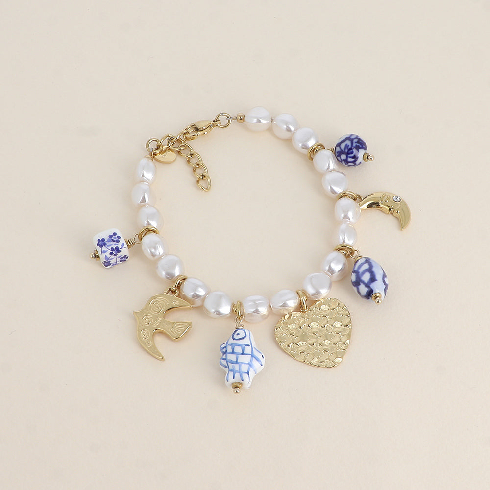 Kullanvärinen charmirannekoru sinivalkoisilla helmillä