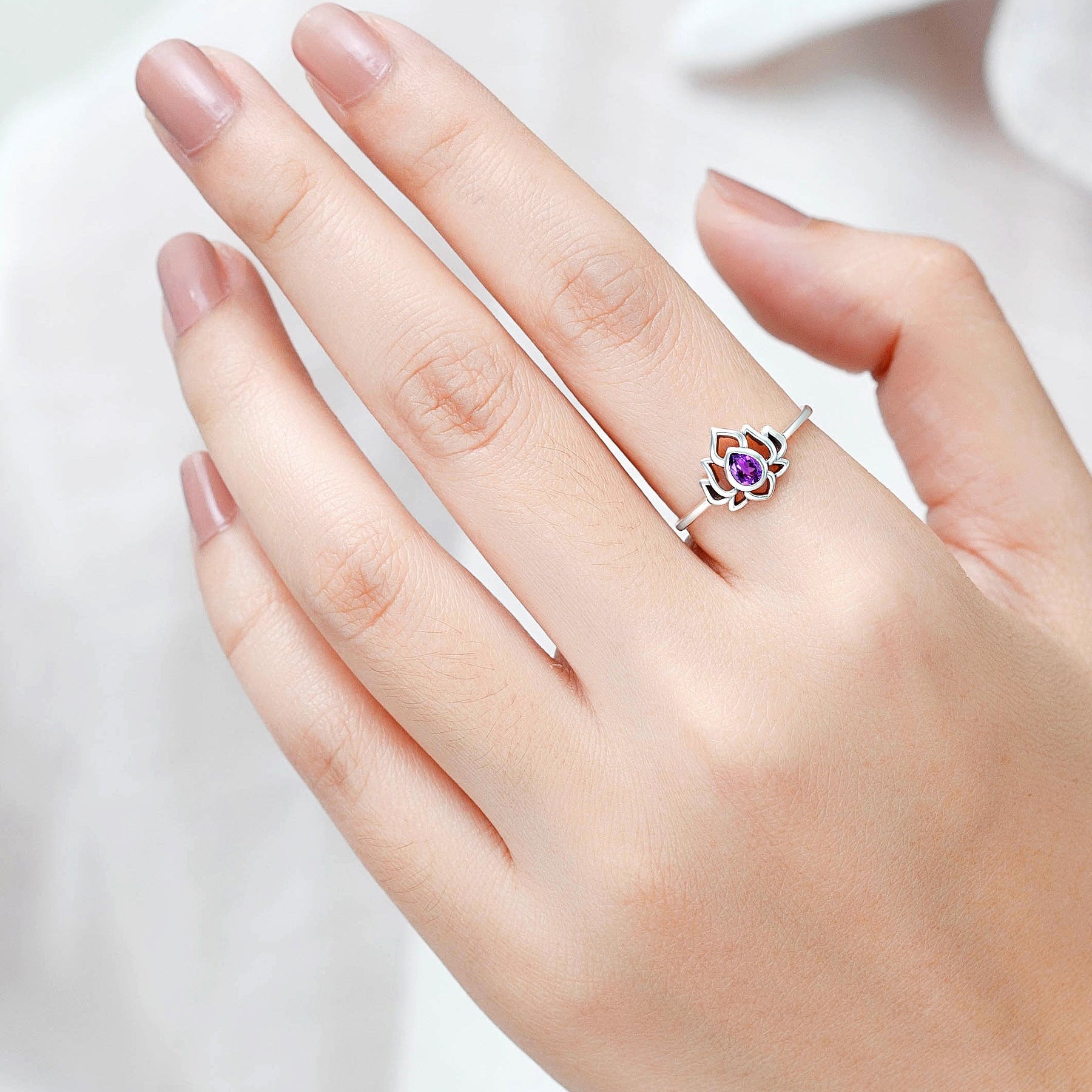 Siro lotus-koristeinen hopeasormus, jossa violetti ametisti.