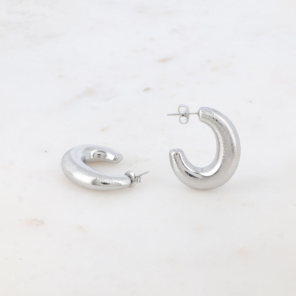 Modernit hopeiset ovaalit rengaskorvakorut harjatulla pinnalla