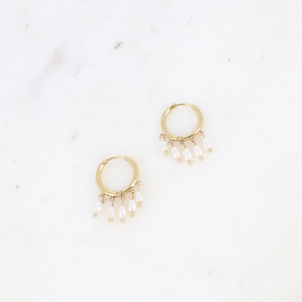 Pienet kultaiset renkaat roikkuvilla helmillä