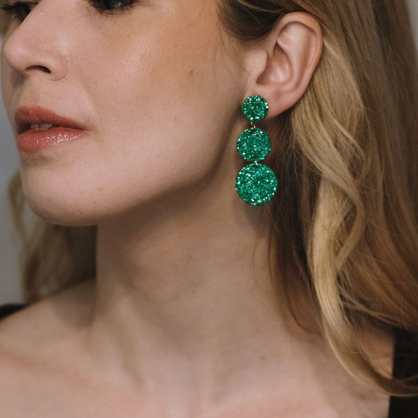 LEMPI®-korvakorut käytössä – Ilona-malli vihreänä versiona mallin korvassa.