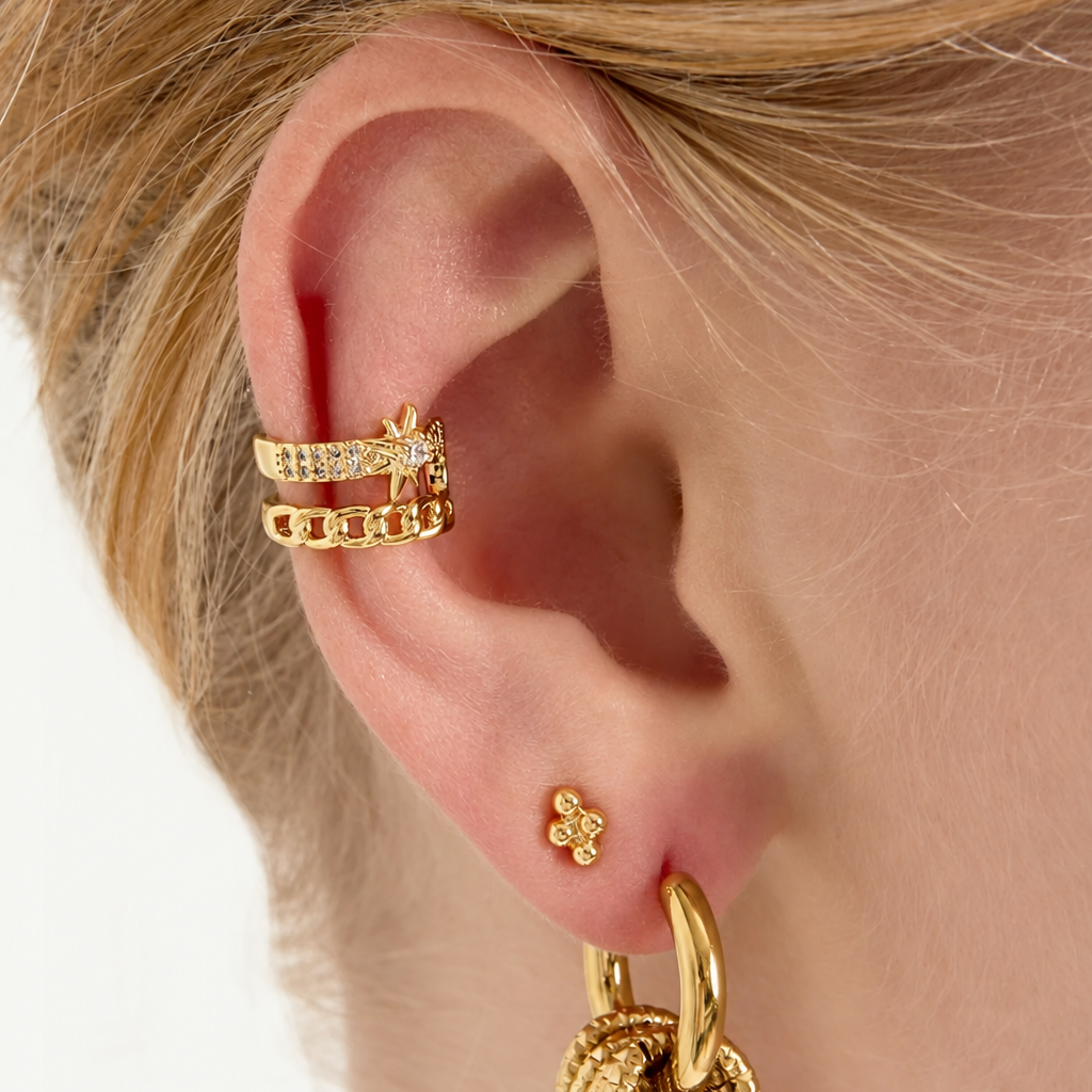 Kullanvärinen Stellar Chain ear cuff, jossa kerroksellinen muotoilu, kristallirivi ja pieni tähtiyksityiskohta.