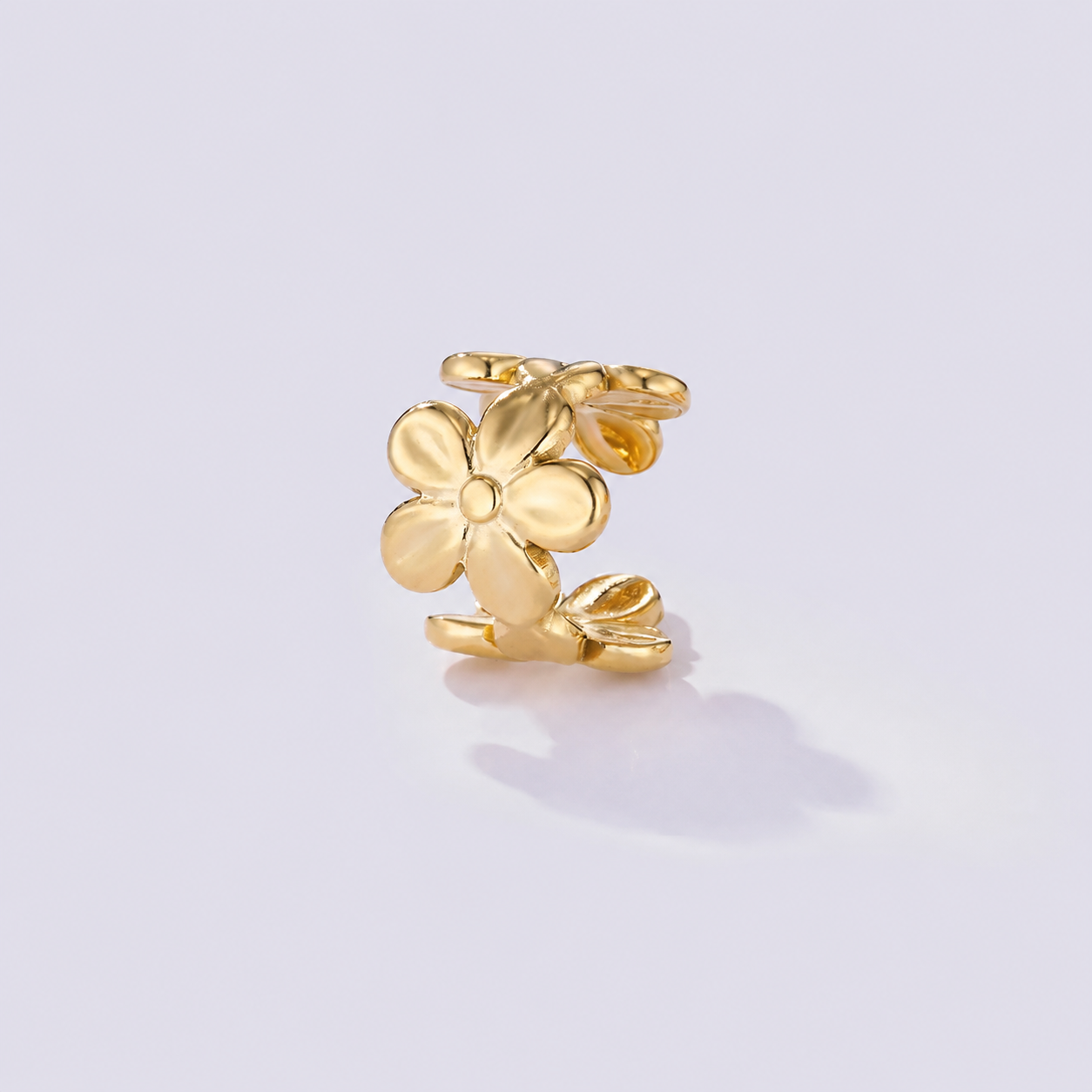 Vedenkestävä kirurginteräksinen ear cuff, kullanvärinen kukkakoriste korvan reunalle