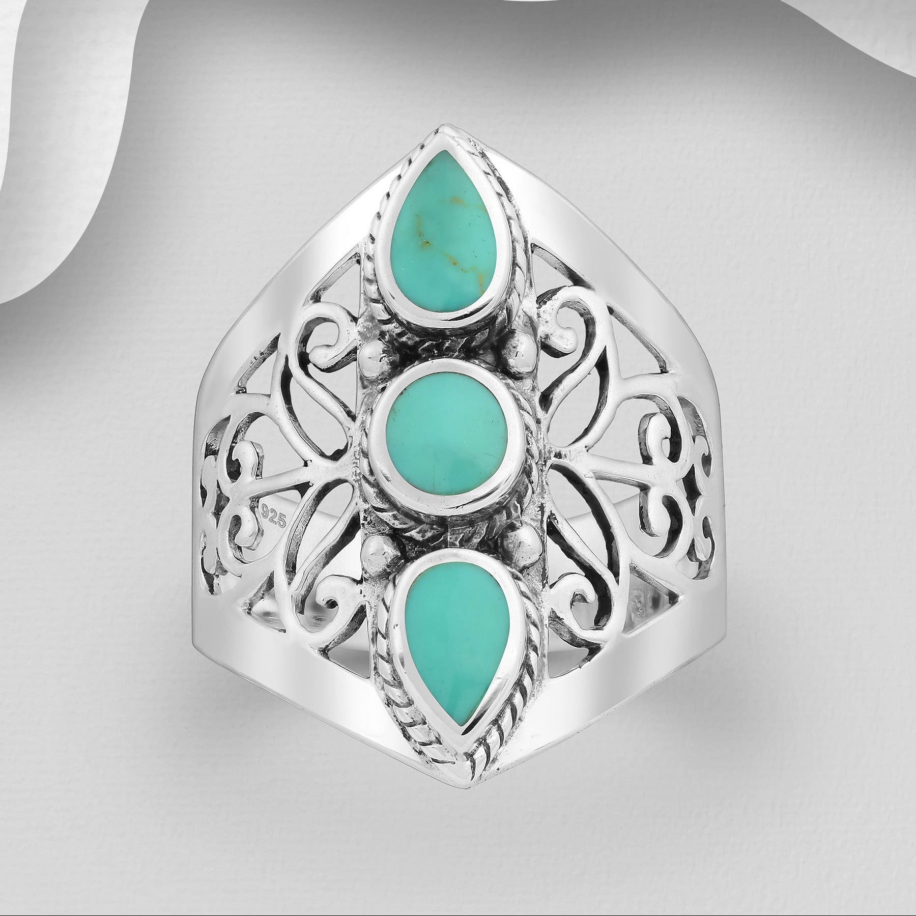 Koristeellinen filigraanihopeasormus, jossa kolme turkoosia kiveä.
