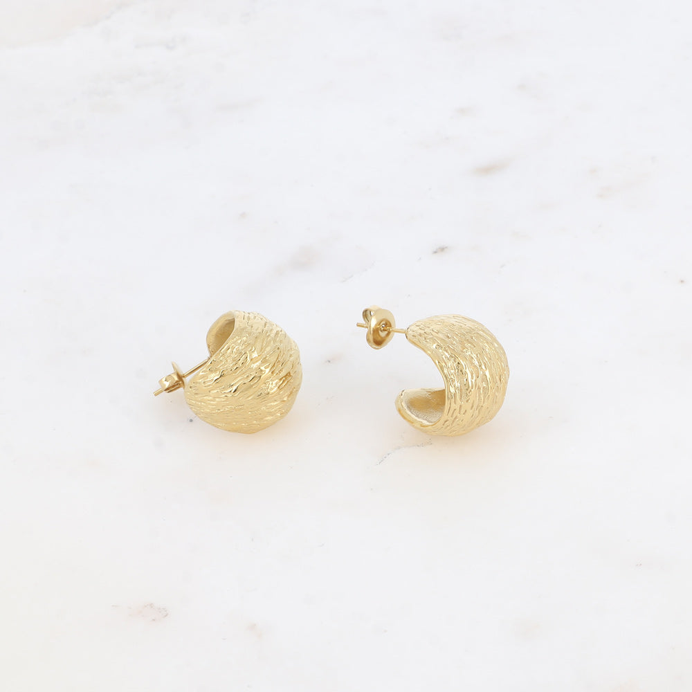 Modernit kultaiset rengaskorvakorut täyteläisellä muodolla.