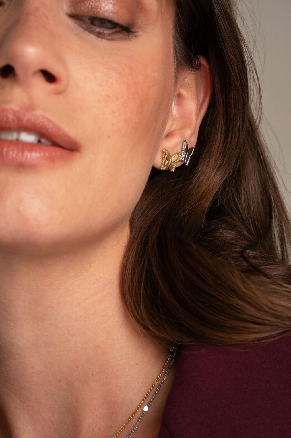 Minimalistiset perhoskorvakorut korvassa käytössä