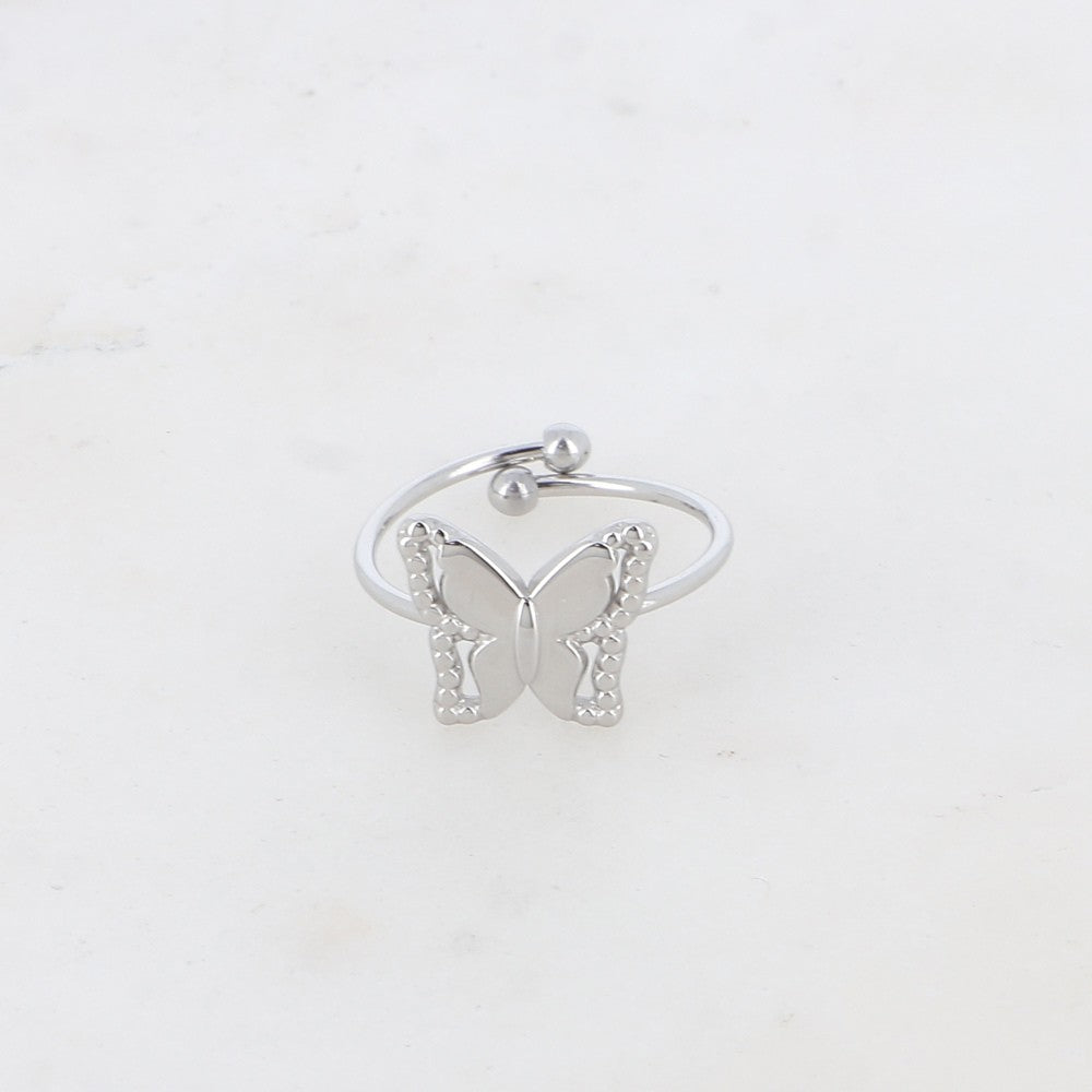 Hopeanvärinen XS perhossormus lähikuvassa vaalealla taustalla