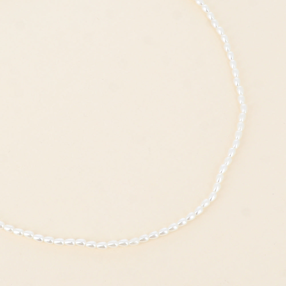 Minimalistinen choker-helmikaulakoru kullan sävyllä