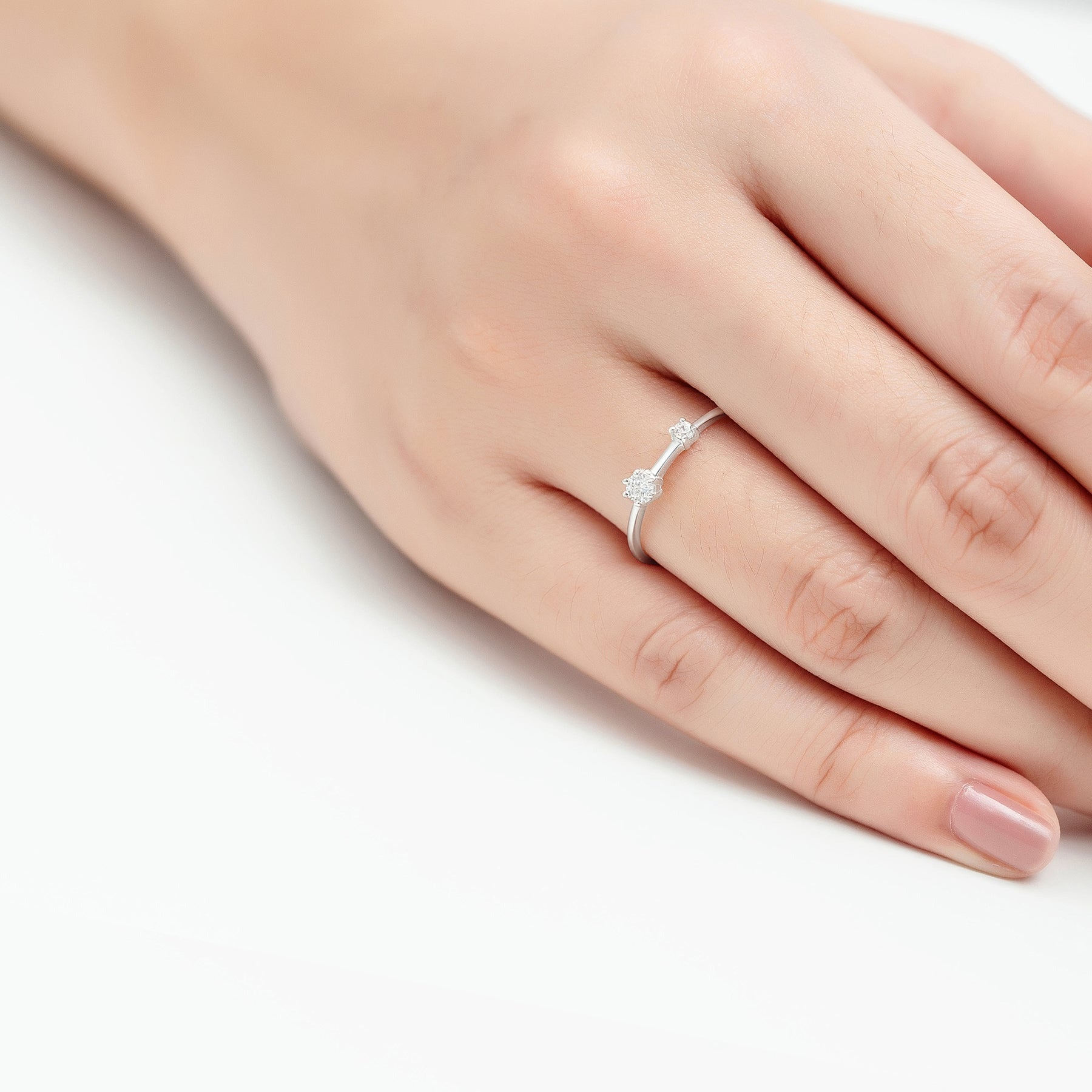 Hopeinen Evelienne-sormus, jossa kaksi eri kokoista CZ-kiveä sirolla rungolla.