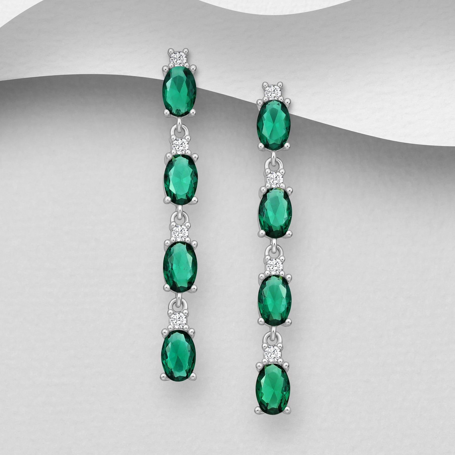 Pitkät roikkuvat hopeakorvakorut smaragdinvihreillä kristalleilla ja tappikiinnityksellä.