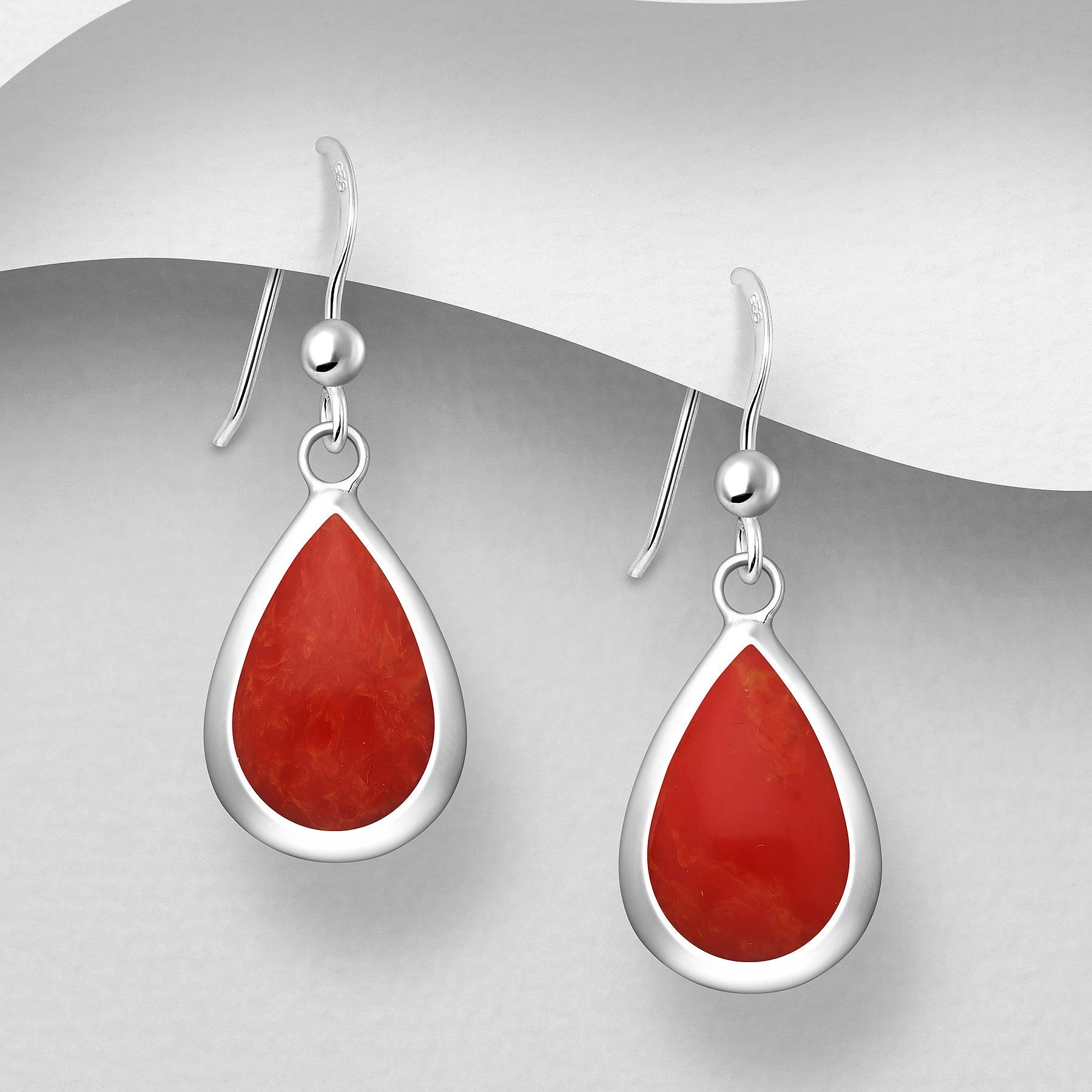Sirot roikkuvat hopeakorvakorut punaisella hartsikoristeella ja bezel-kehyksellä.