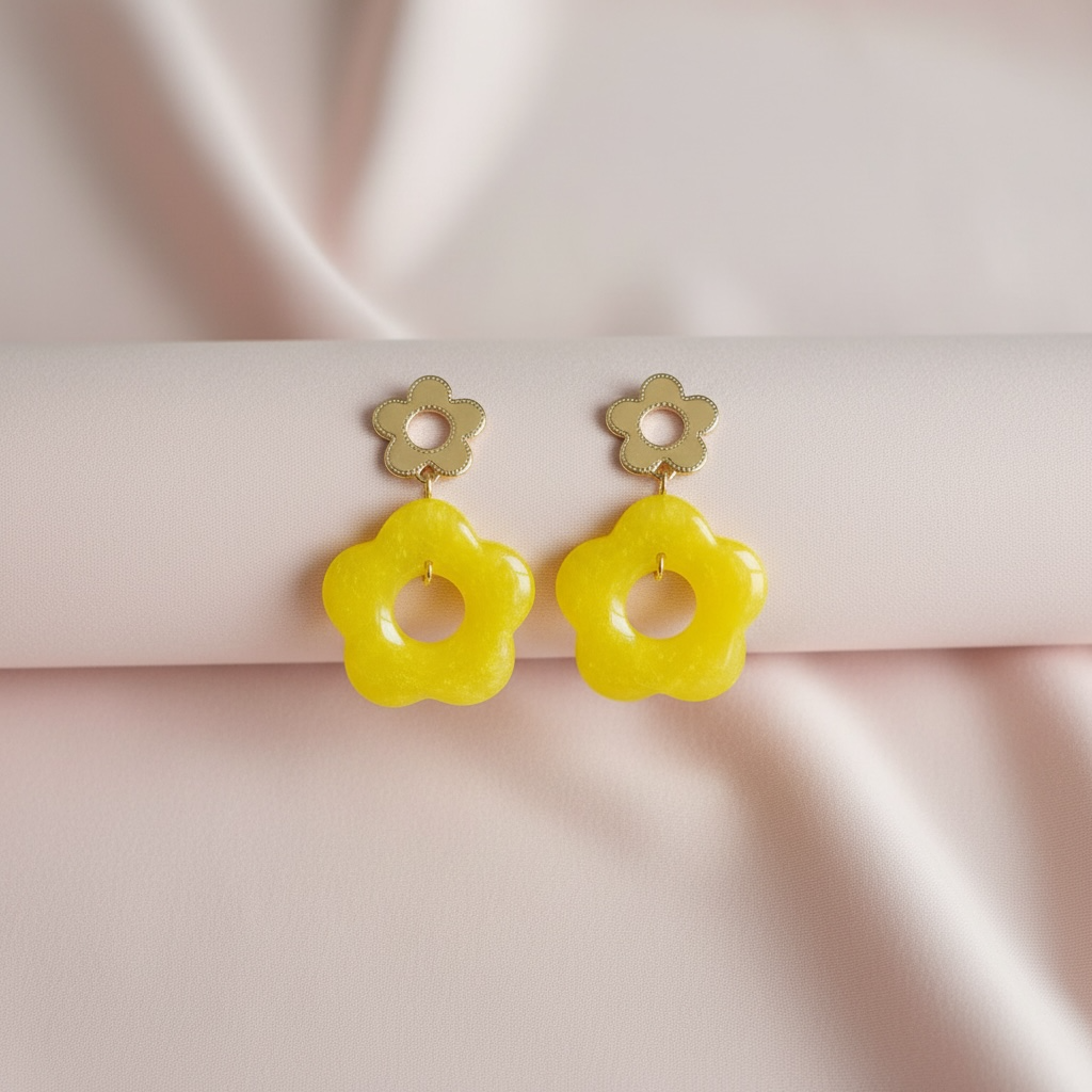 Kesäiset kukkakorvakorut FRENCH RIVIERA Soleil Loop – raikas keltainen sävy ja moderni muoto.