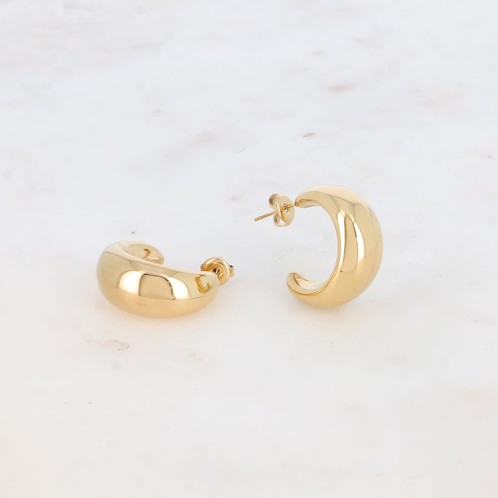 Modernit kultaiset rengaskorvakorut pyöristetyllä muodolla