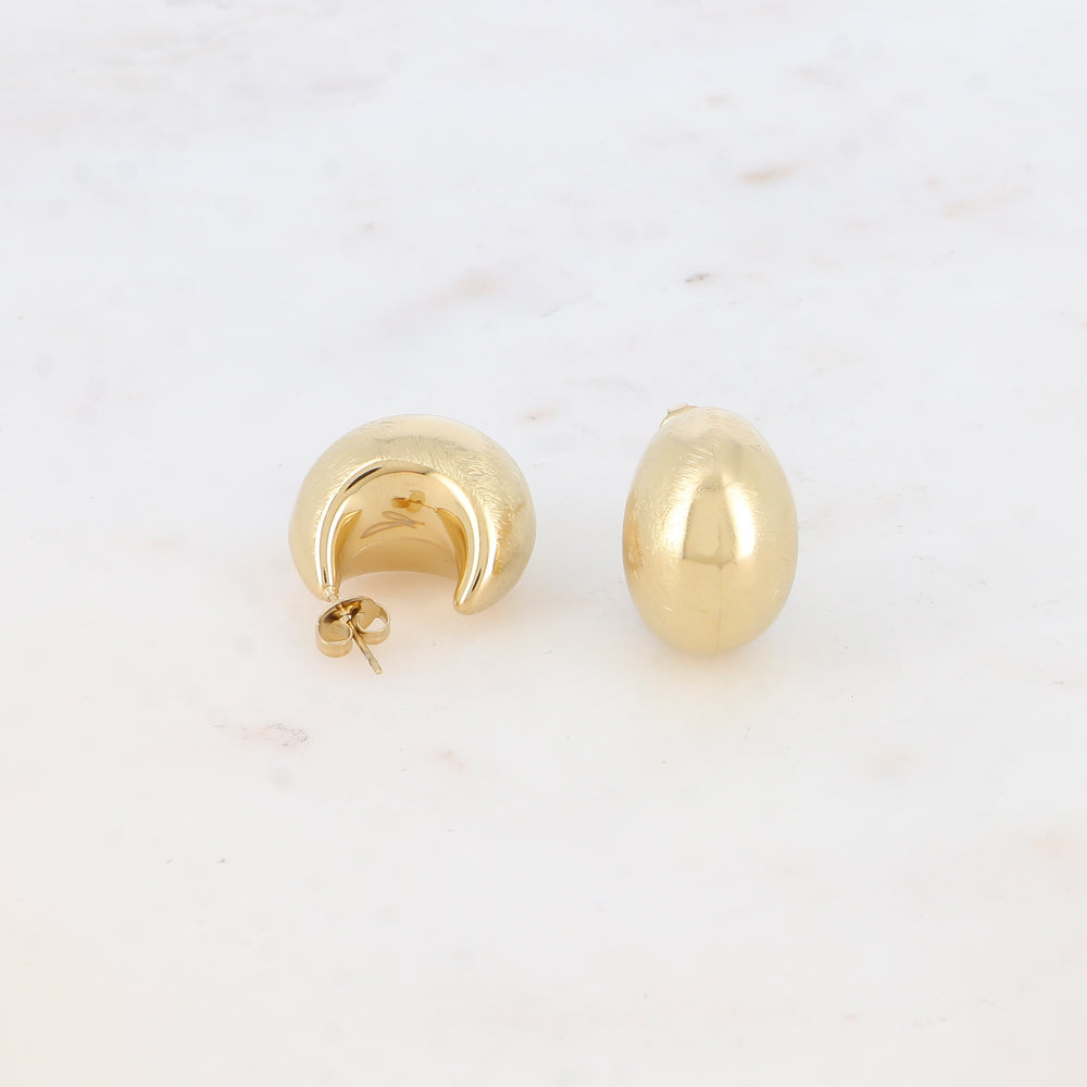 Modernit kultaiset rengaskorvakorut pehmeällä muodolla.