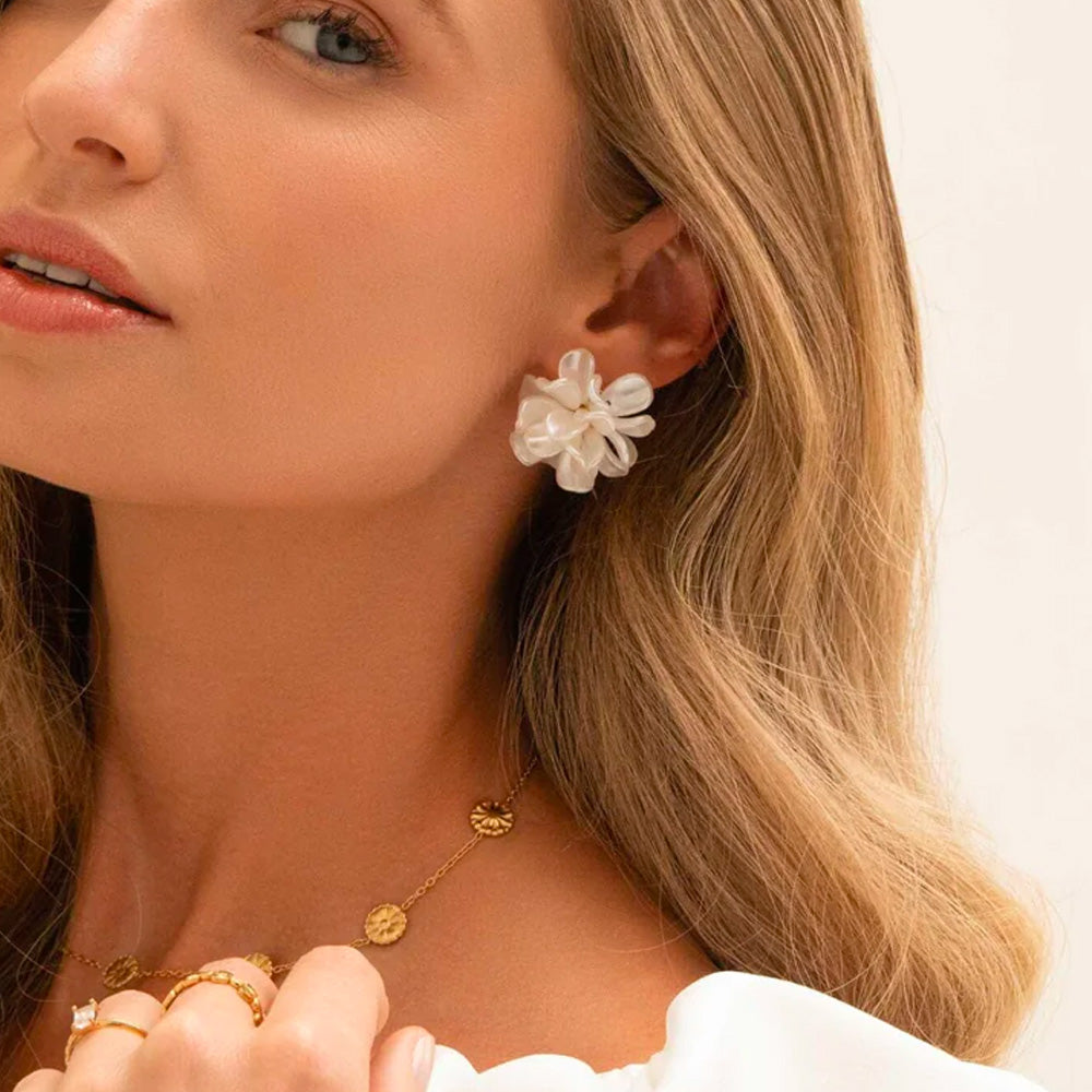 Bohm Paris Iris valkoiset kukkakorvakorut helmiäishohteella mallin korvassa.