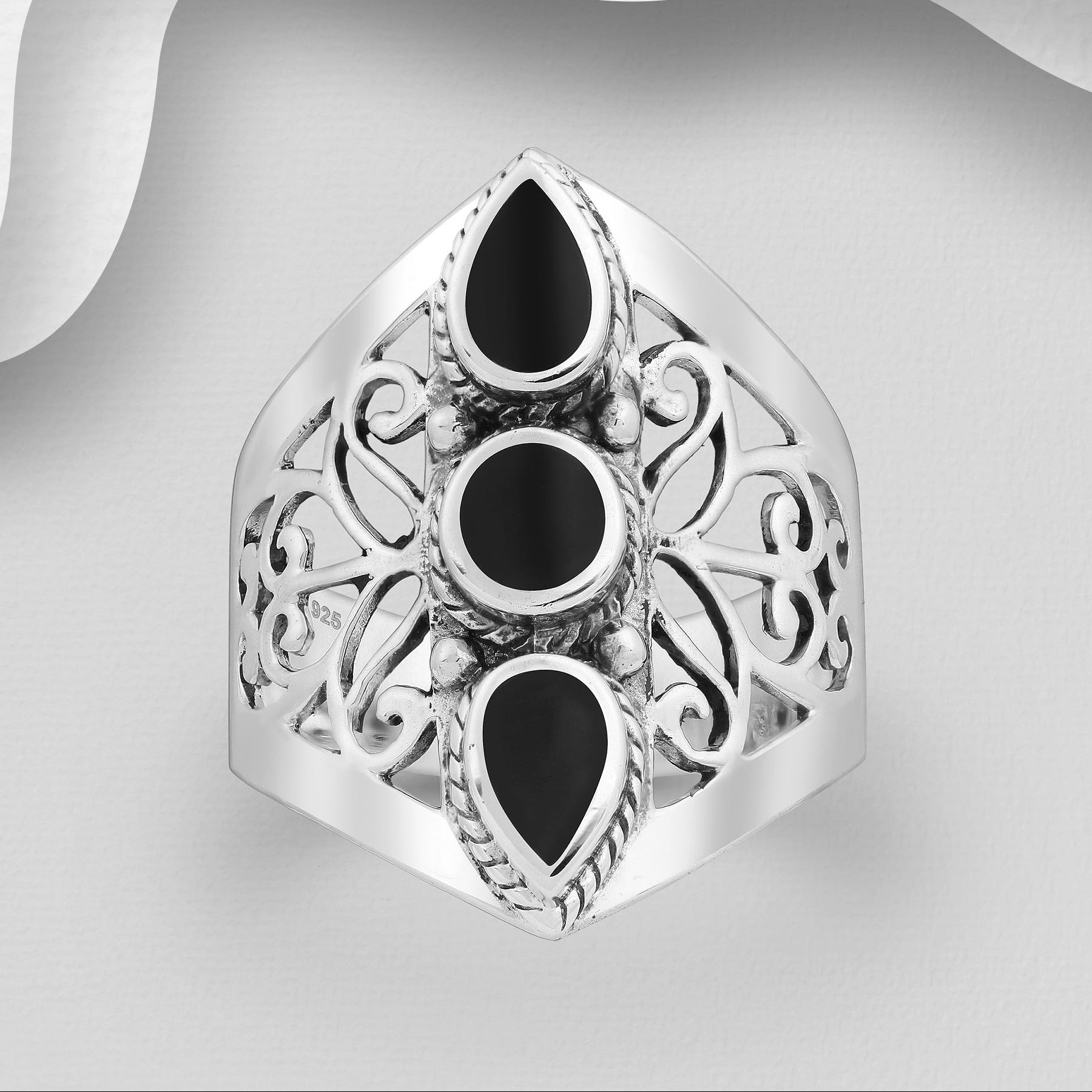 Koristeellinen filigraanihopeasormus, jossa kolme mustaa koristekiveä.