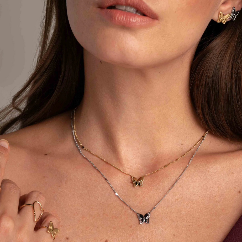 Kullanvärinen perhoskaulakoru ohuella ketjulla lähikuvassa