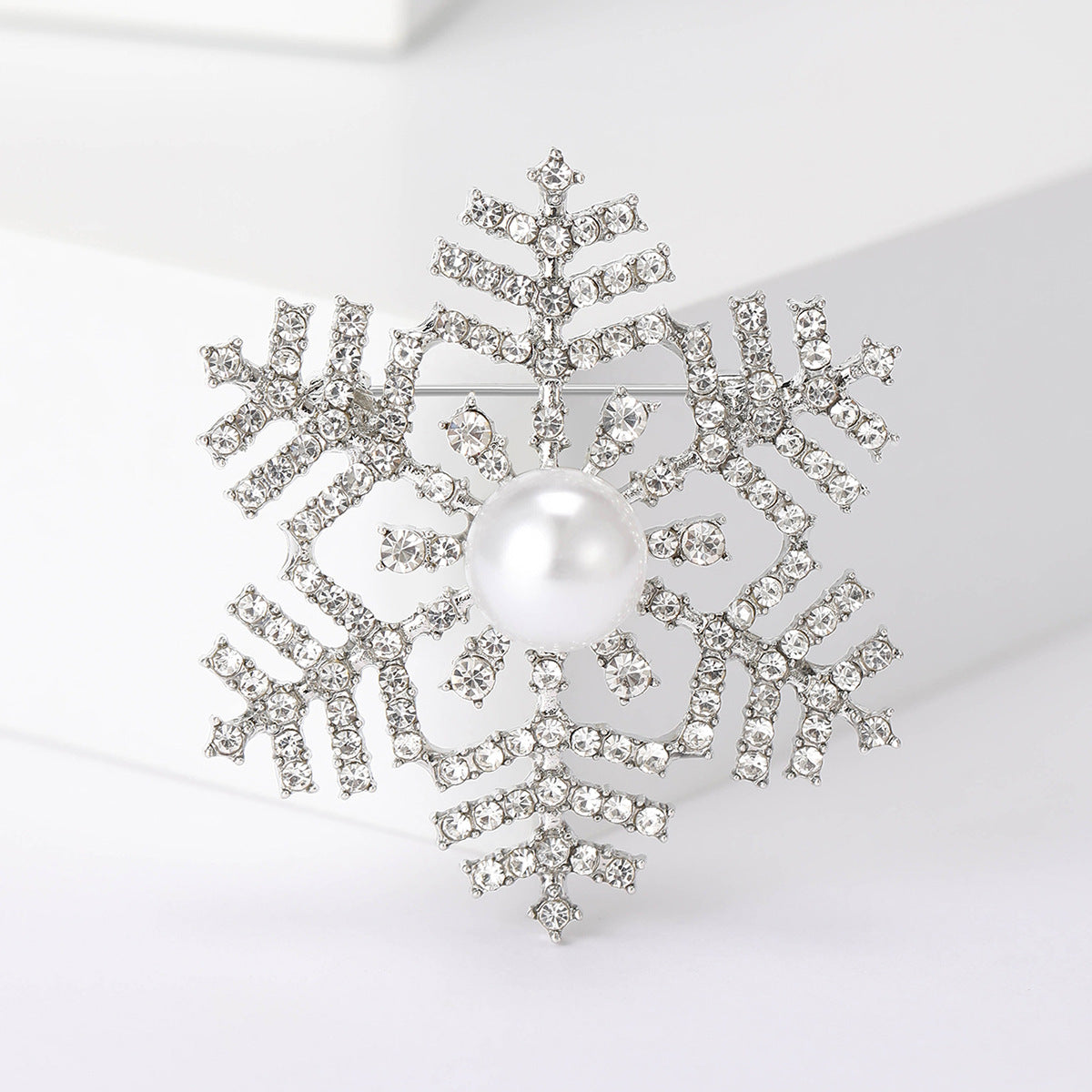 Kimalteleva hopeansävyinen lumihiutalerintaneula kirkkailla kivillä – Romeo & Julia