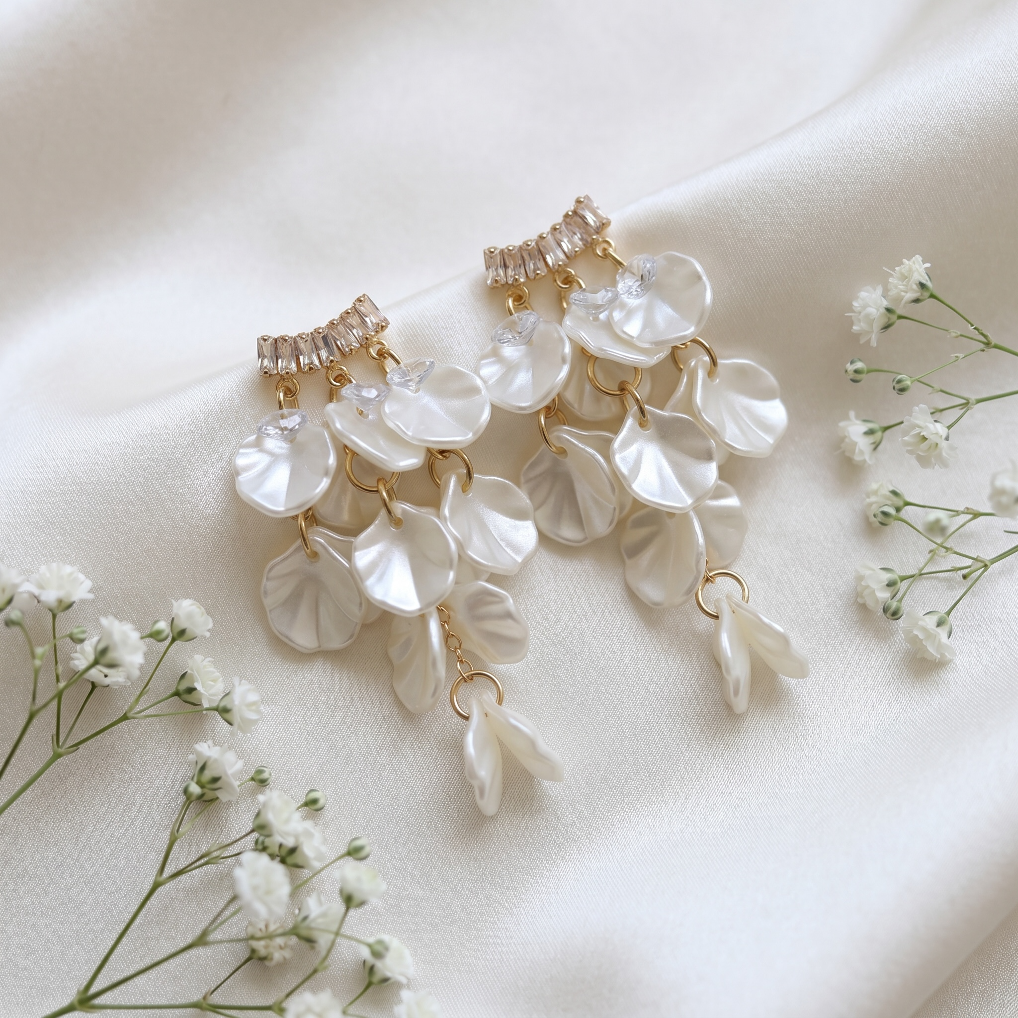 FRENCH RIVIERA Ivory Rain -korvakorut valkoisella satiinitaustalla