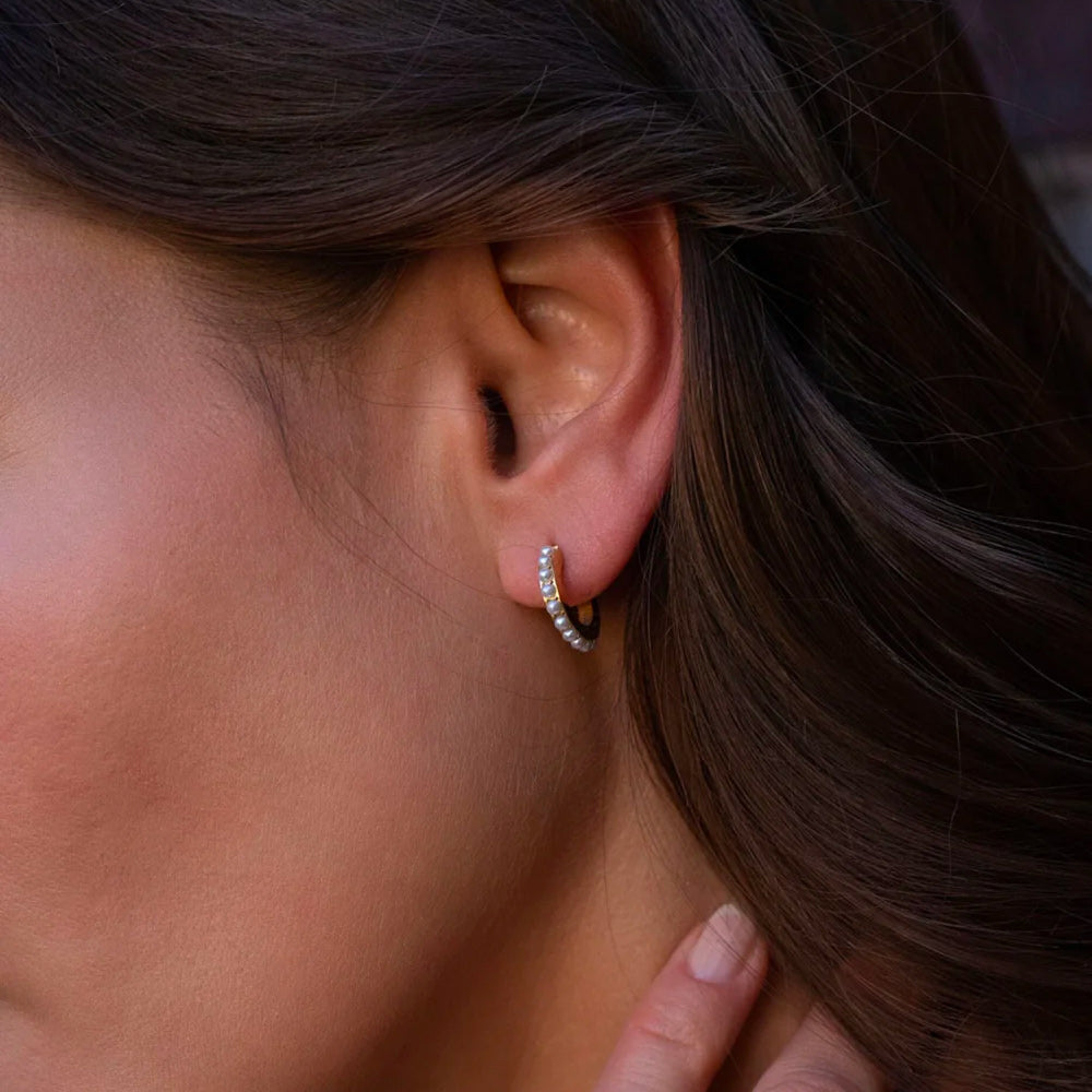 Pienet helmikorvakorut korvassa lähikuvassa