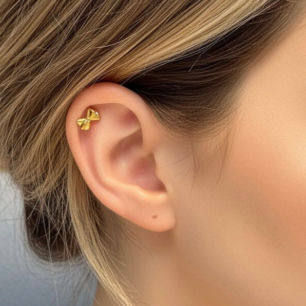 Bow rusettilabret lähikuvassa, kullattu rustokoru helixiin.