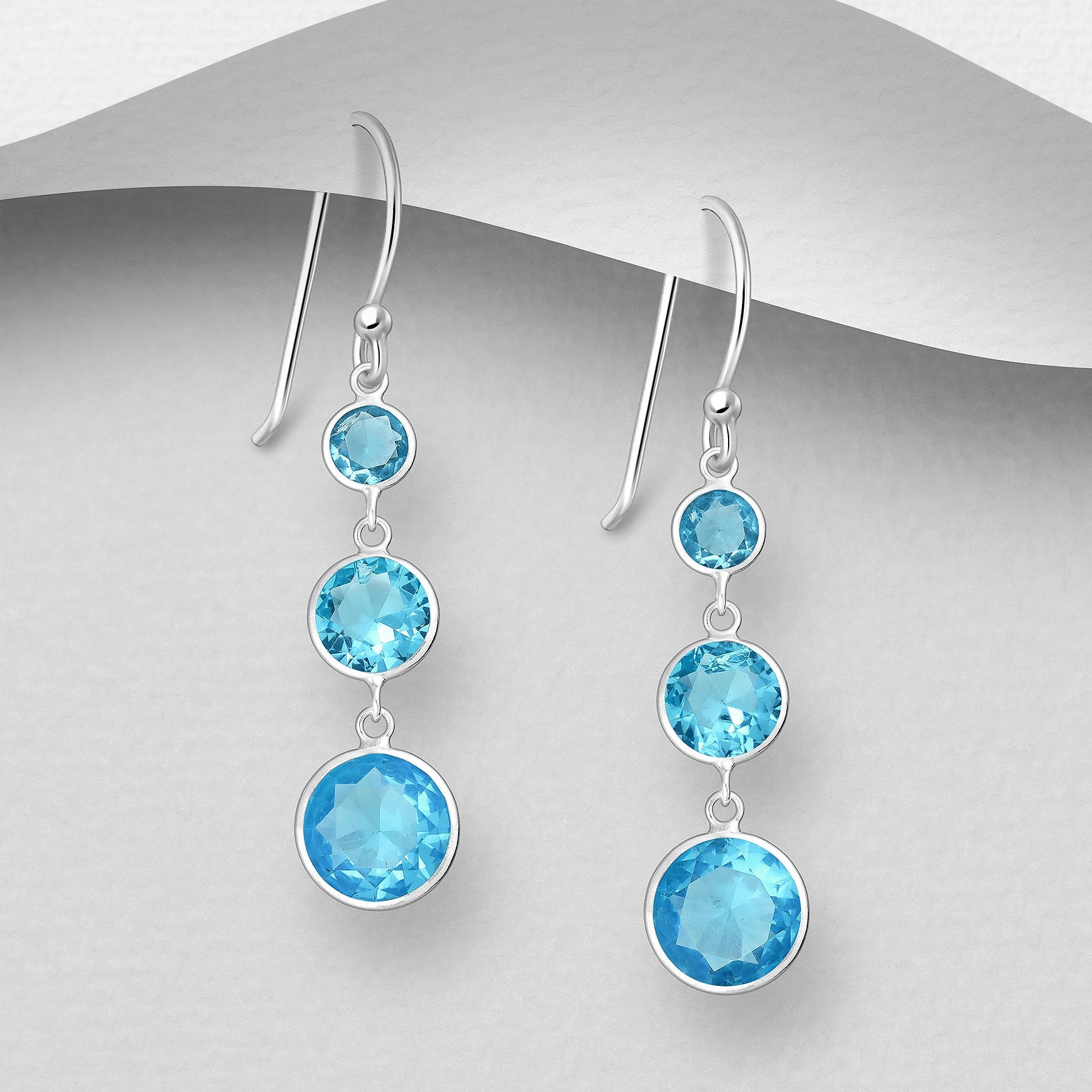 Pitkät roikkuvat hopeakorvakorut kolmella turkoosilla kristallilla.