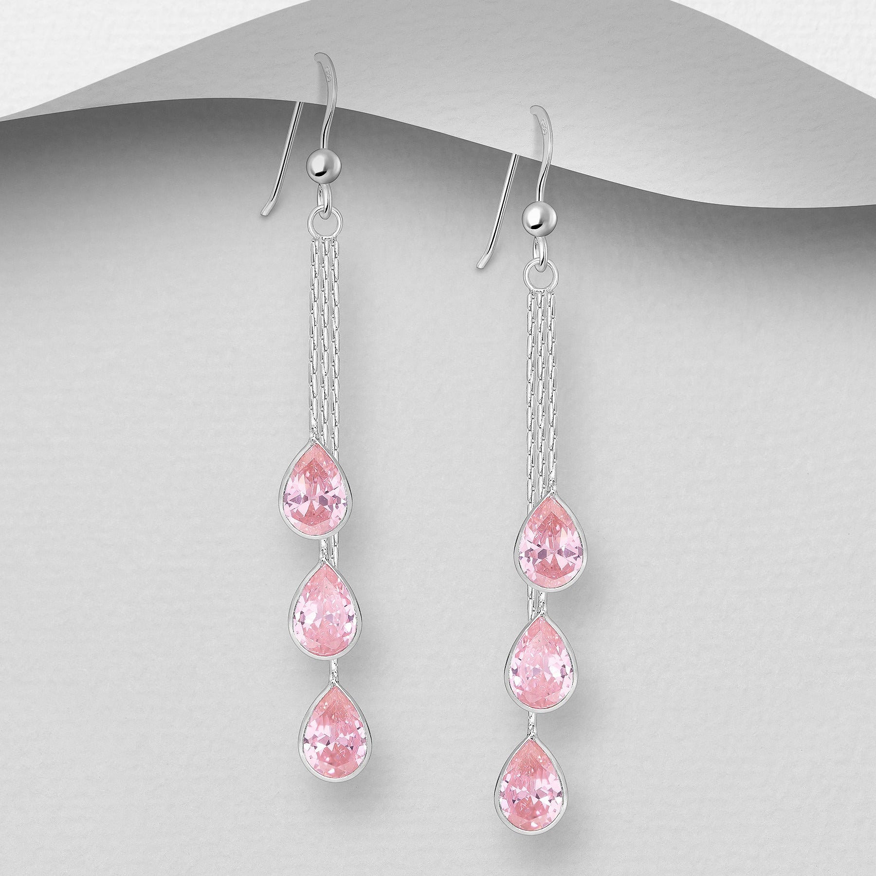 Pitkät roikkuvat hopeakorvakorut kolmella vaaleanpunaisella kristallilla, siro ja kevyt malli.