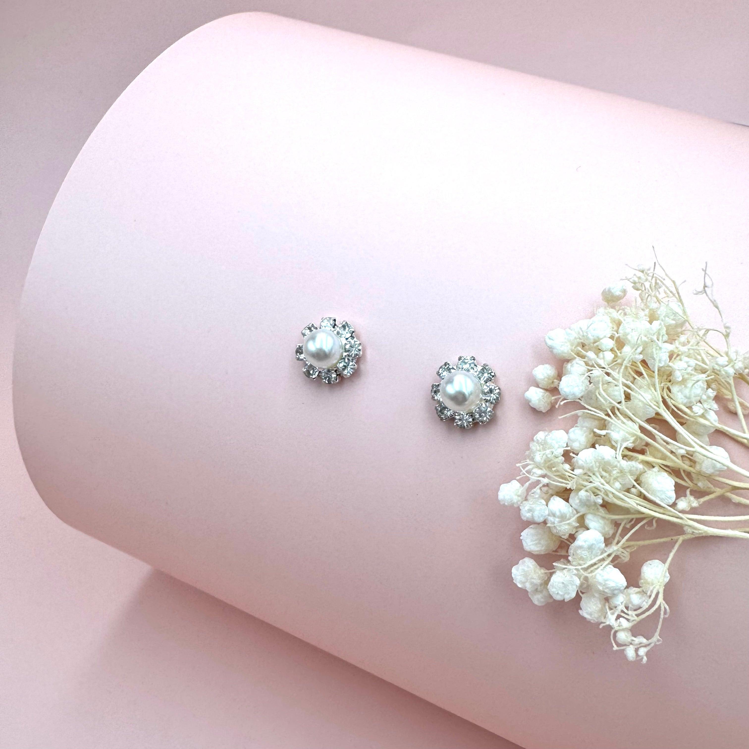 Viviana juhlakorusetti – helmikorvakorut strasseilla vaaleanpunaisella taustalla